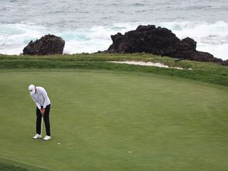 Ludvig Aberg hitting a putt in windy conditions at the Pebble Beach Pro-Am