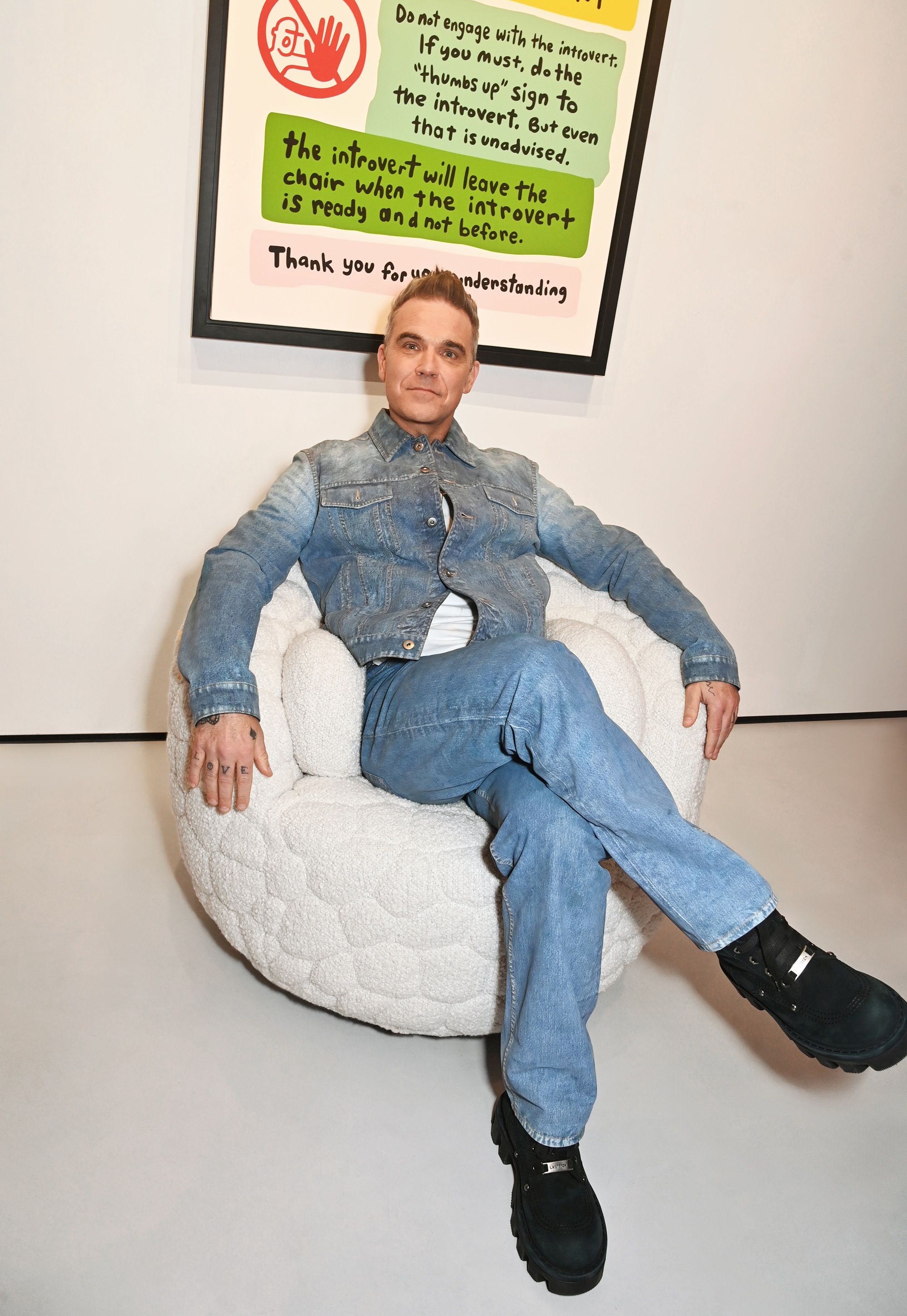 Robbie Williams sitting in his chair he designed with Moooi