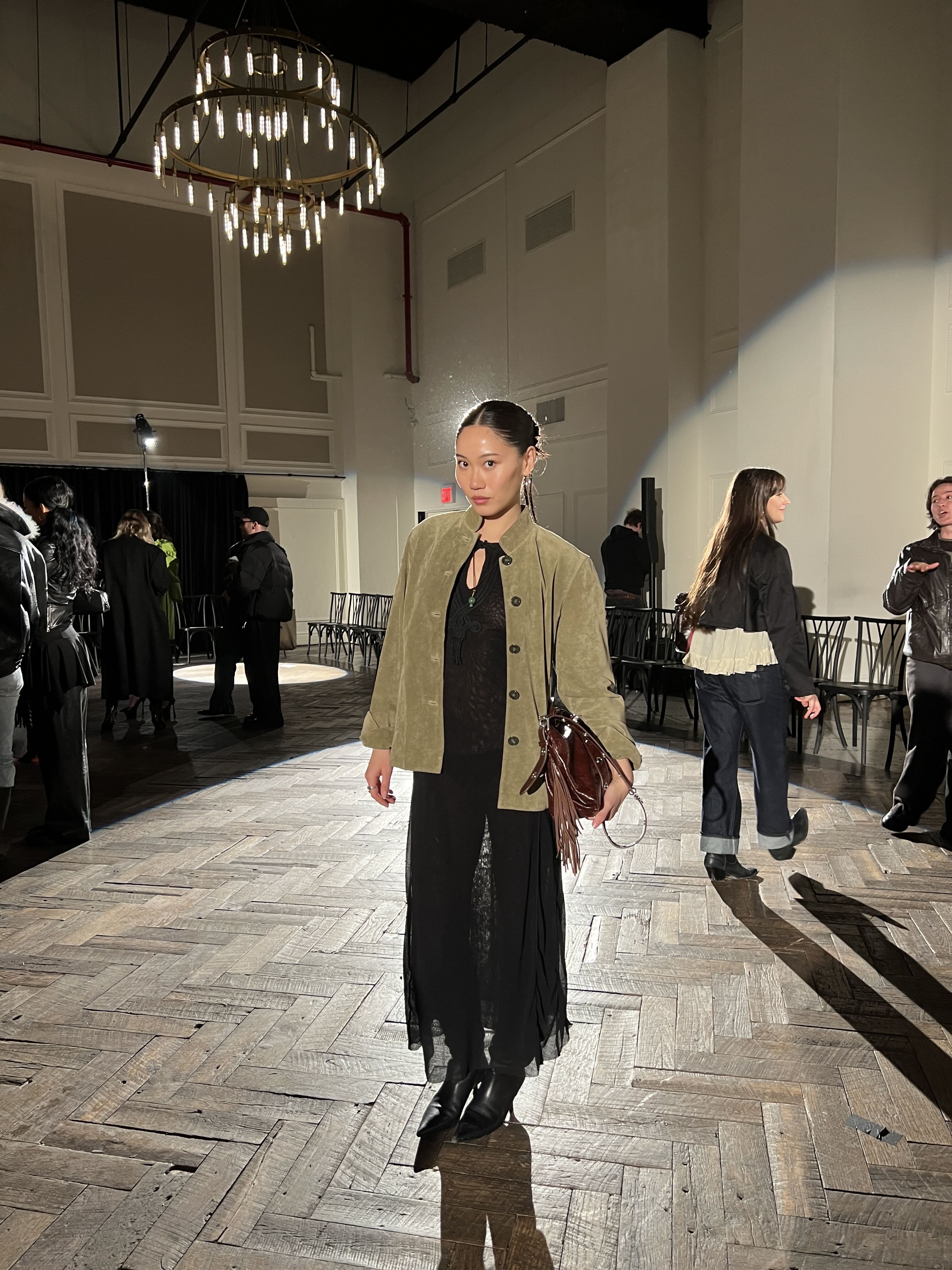 Vivian Li wearing a black dress and green jacket