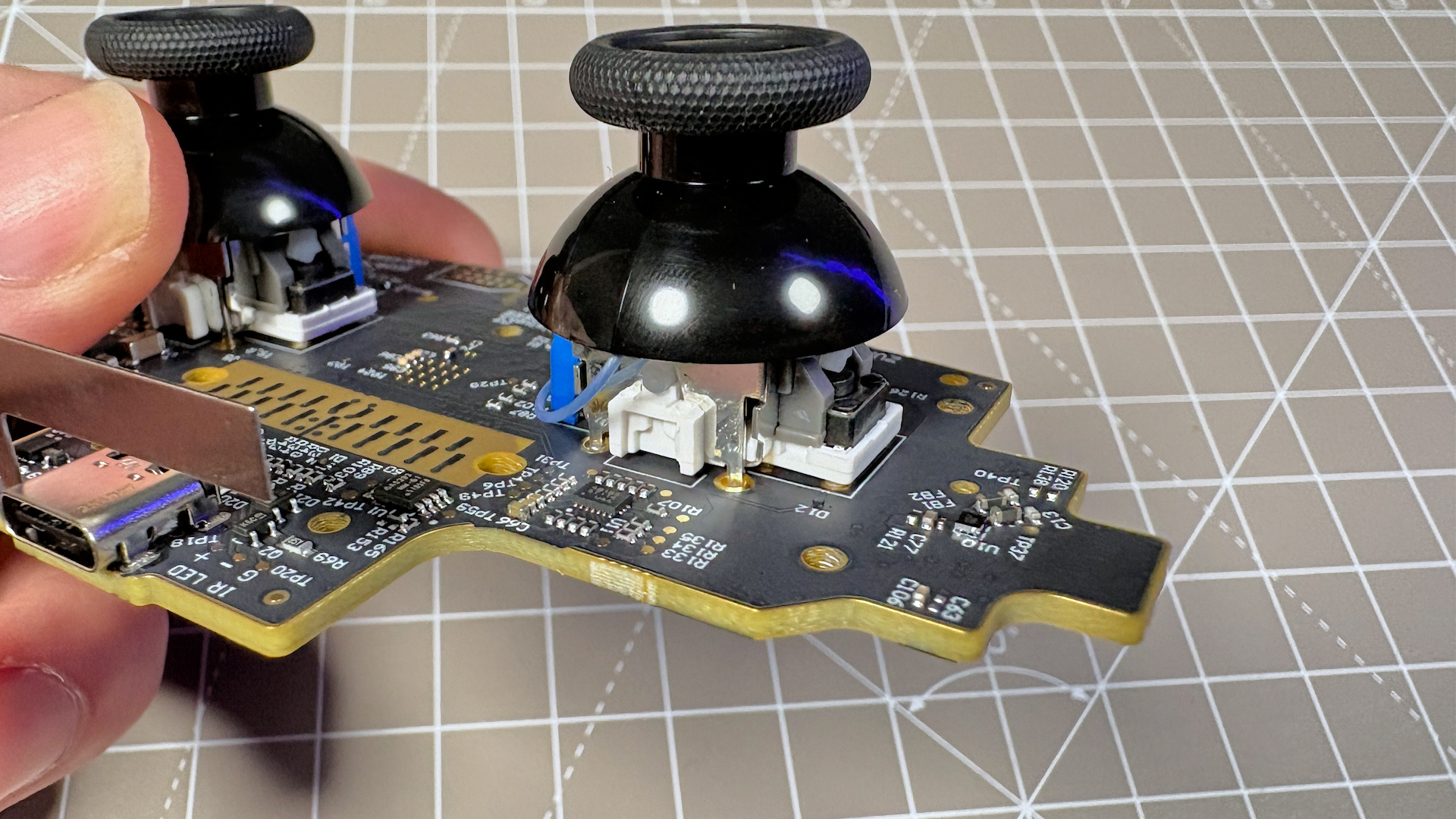 The Steam Controller on a desk during a teardown, with various parts removed.