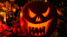 Carved pumpkin with scary face sits on table