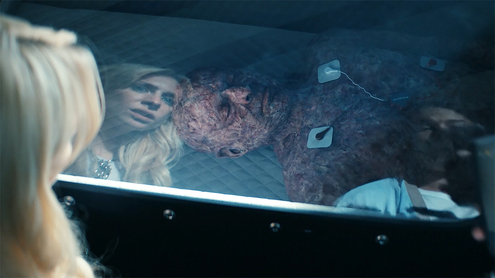 Cate and Jordan staring at a scarred man in a hyperbaric chamber in Gen V season 2 episode 4