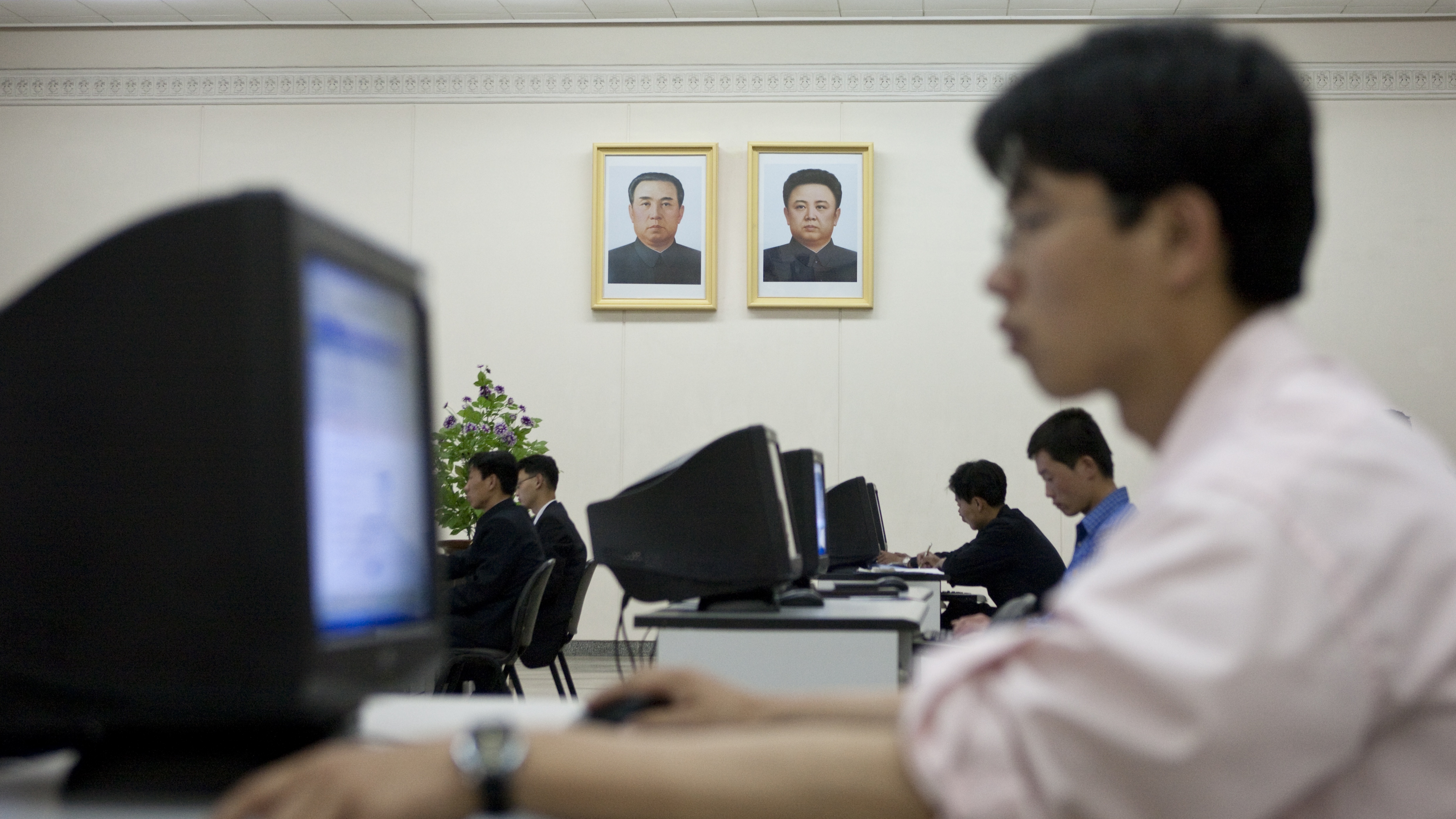 PYONGYANG, NORTH KOREA - MAY 22: North Korean man using a computer under the Dear Leaders pictures in the Grand people's study house, Pyongan Province, Pyongyang, North Korea on May 22, 2009 in Pyongyang, North Korea.