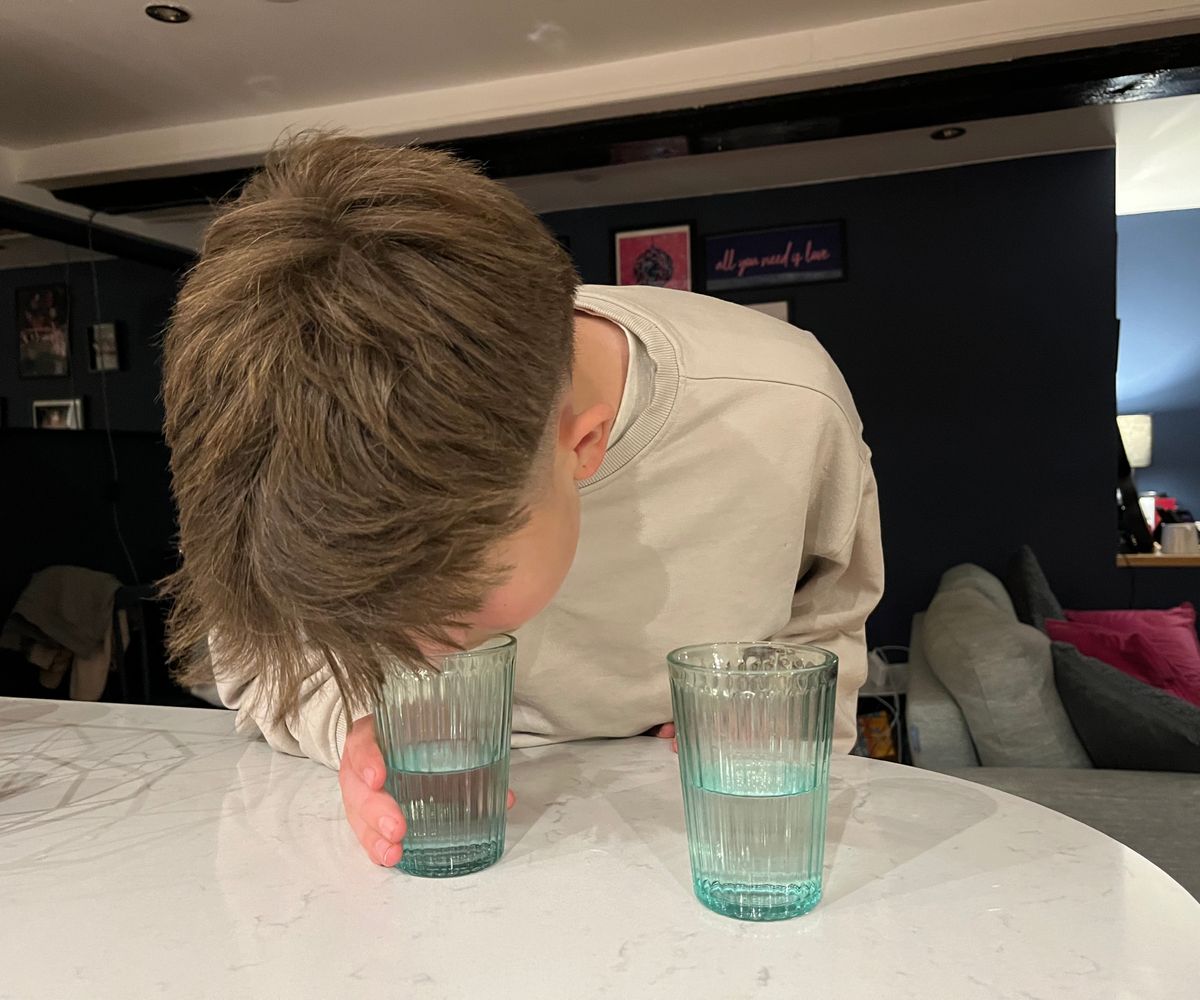 glasses of water on worktop, followed by boy smelling and tasting water