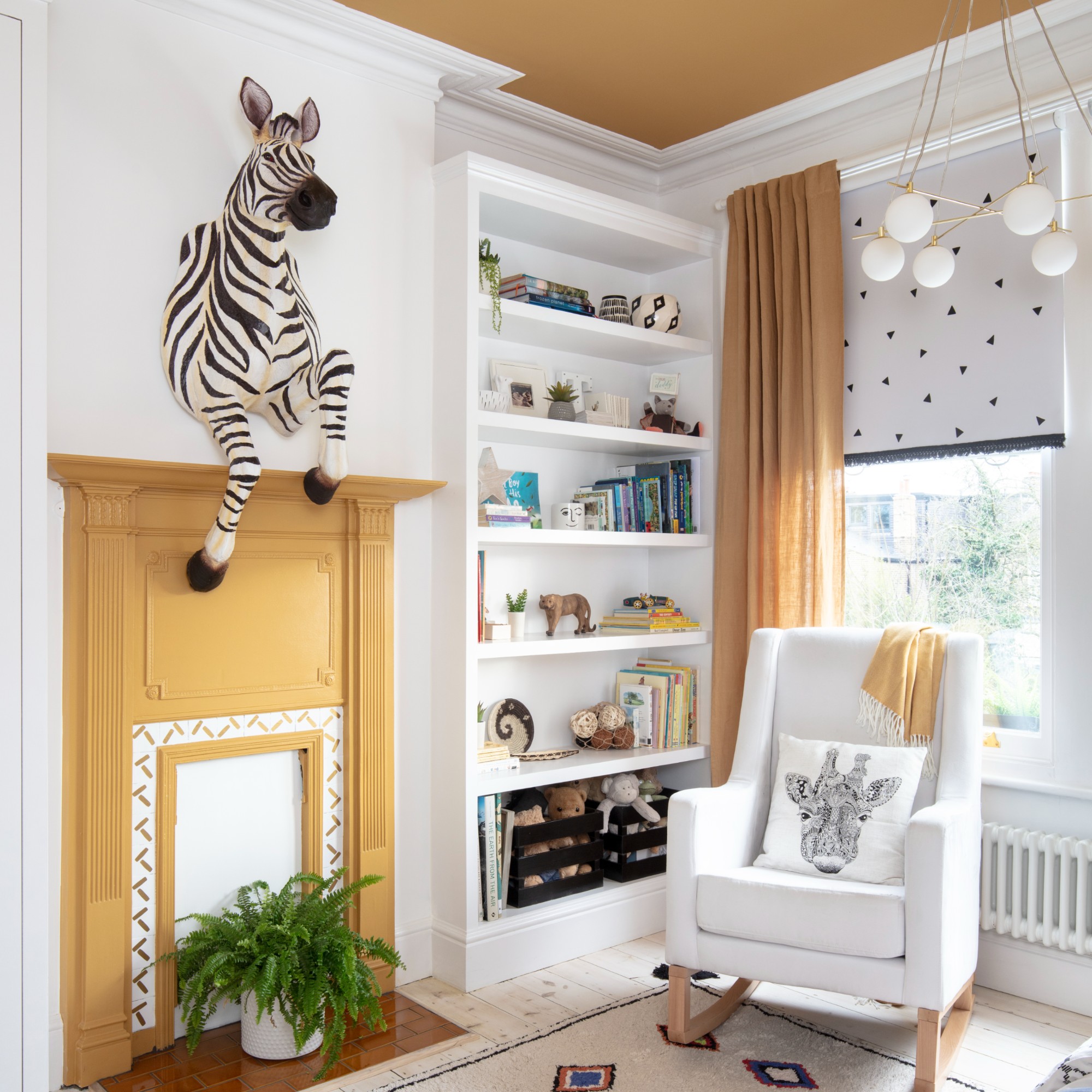 A room with a yellow fireplace and a yellow-painted ceiling with a large zebra-shaped decor hanging above the fireplace
