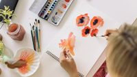 Best watercolour paints: a woman painting flowers with watercolours