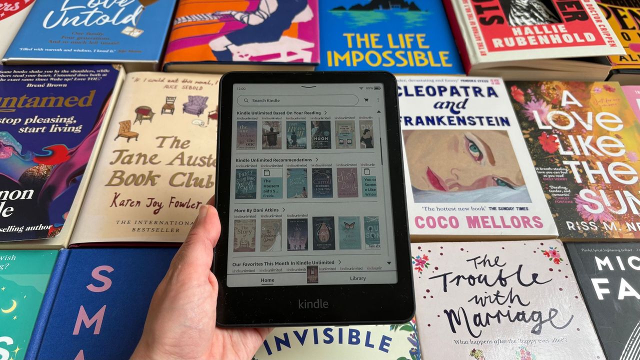 The Kindle Colorsoft with Kindle Unlimited open in front of books