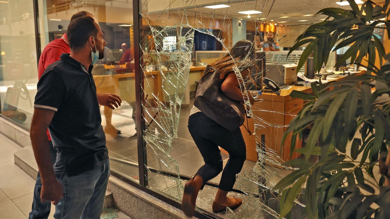 The glass window of a Beirut bank is left smashed after a heist 