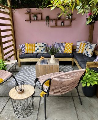 DIY pergola and DIY corner sofa with pink painted garden walls