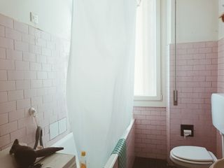 White clean shower curtain in pink bathroom