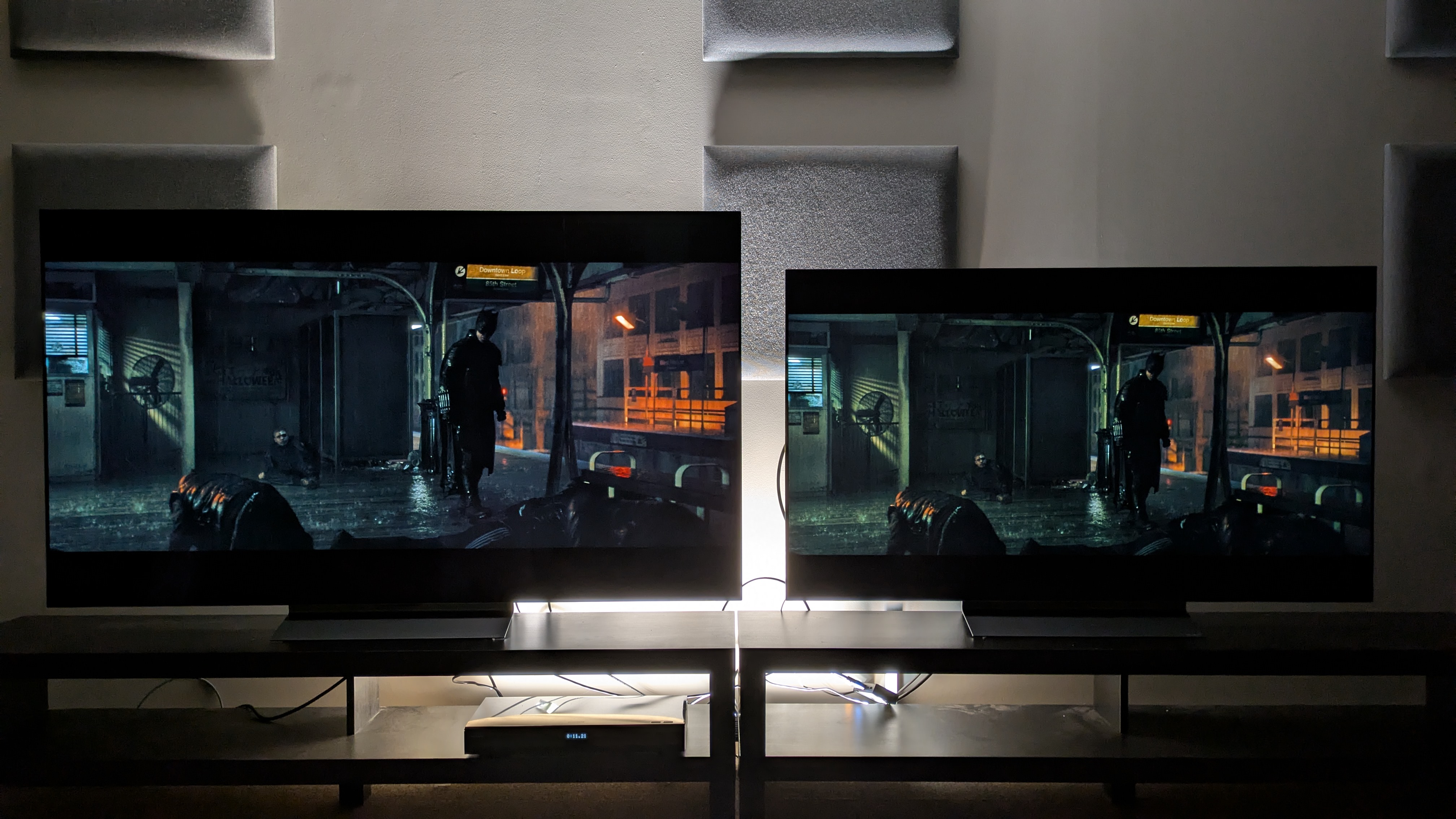 LG C6 (left) and LG C5 (right) OLED TVs showing Batman standing in a dark subway from The Batman. Both TVs have great contrast, but the C6's appears that little more refined with more shadow detail