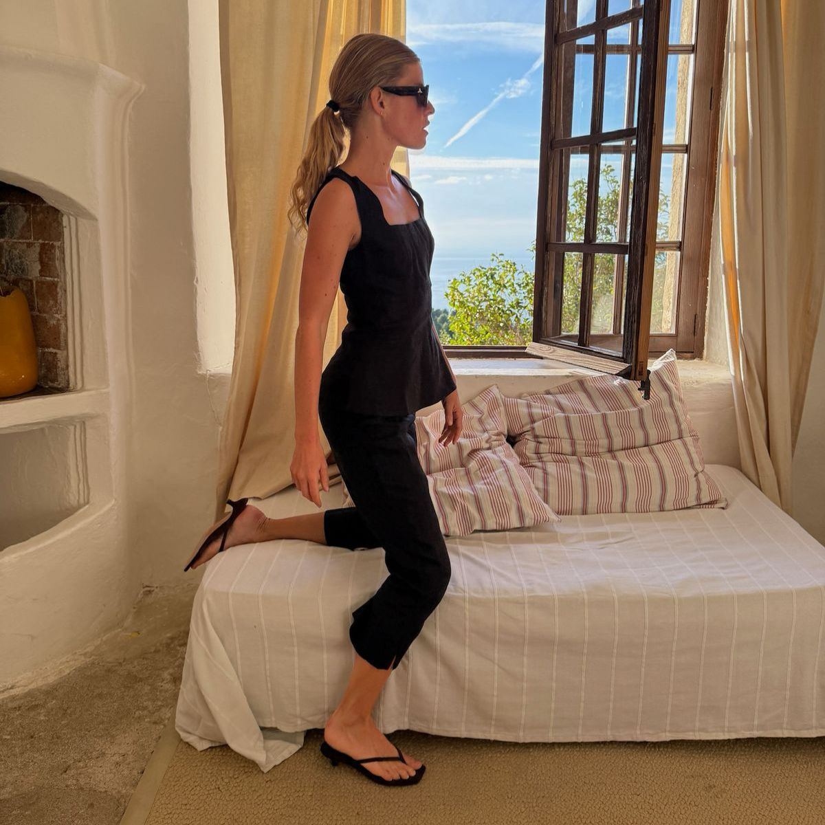 An image of  Alice Pilate wearing capri leggings with flip-flops, one of the best shoes to wear with capri leggings.