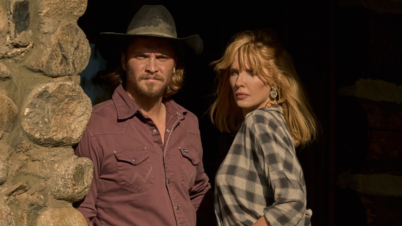 From left to right: Luke Grimes and Kelly Reilly standing next to each other on Yellowstone.