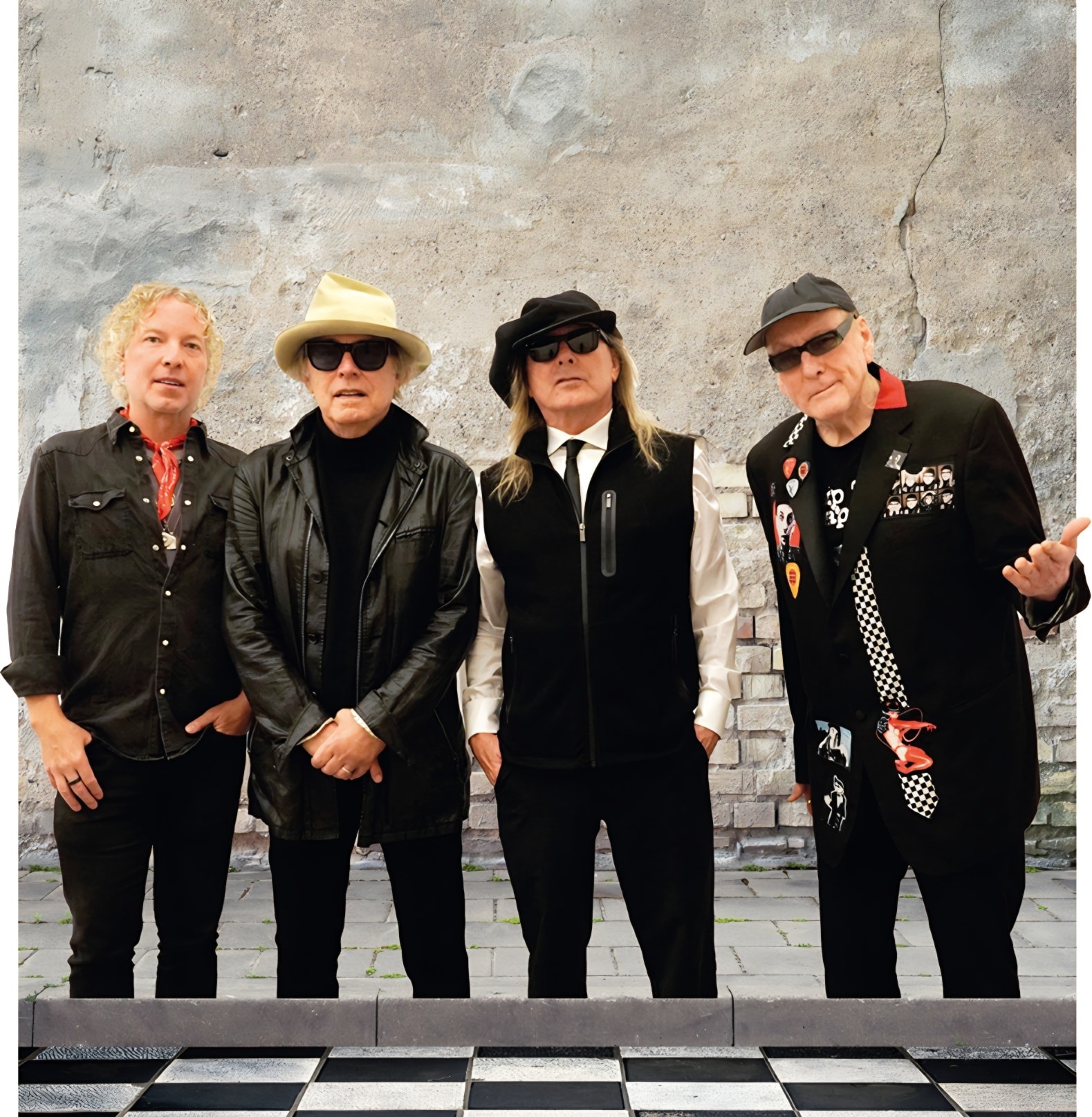 Cheap Trick standing in front of a brick wall