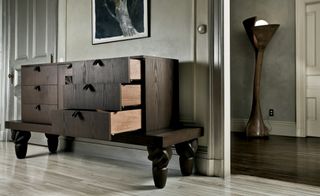 A Julie Williams painting hangs above a ‘Samba’ cabinet with leather drawer handles, from the Wendell Castle Collection