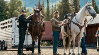 From left to right: Logan Marshall-Green standing with a horse and Luke Grimes standing with a horse in marshals. 