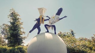 Angine de Poitrine in costume, dancing on a concrete globe