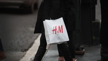  A shopper walks along the Magnificent Mile with a bag of merchandise from H&M