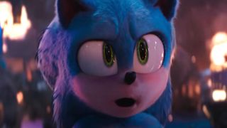 Sonic stands in front of a scene of destruction with a look of shock in Sonic the Hedgehog 3.