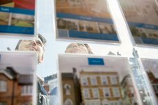 House buyers looking through estate agent window