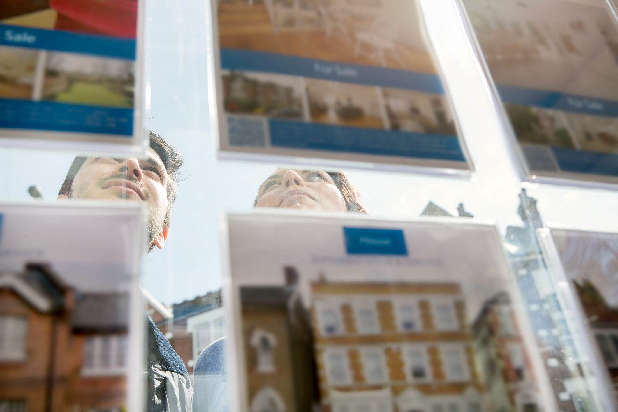 House buyers looking through estate agent window