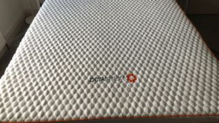 The Octasmart Deluxe Mattress Topper spread out on top of a mattress