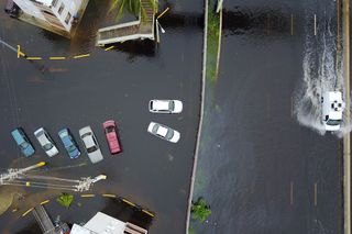 Cars drive through a flooded road in the aftermath of Hurricane Maria in San Juan, Puerto Rico, Thursday, Sept. 21, 2017.