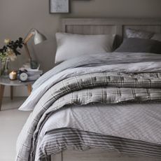 Grey and white bedroom with bed and side table