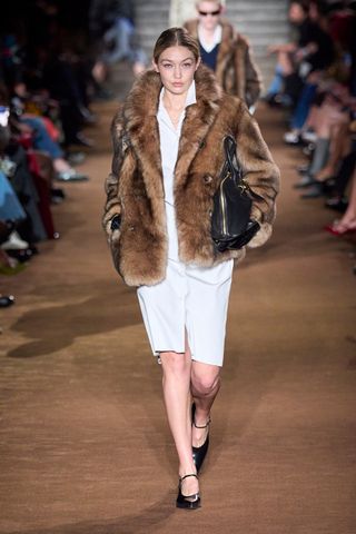 Look da passarela outono/inverno 2024 da Miu Miu com um casaco peludo.