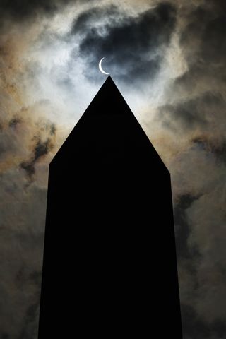 The solar eclipse is seen above the Washington Monument on April 08, 2024 in Washington, DC.