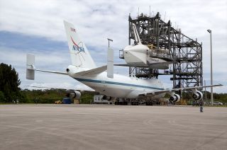 NASA's Shuttle Carrier Aircraft moves into position under shuttle Endeavour, suspended in the Mate-Demate Device at the Shuttle Landing Facility at the Kennedy Space Center in 2012.