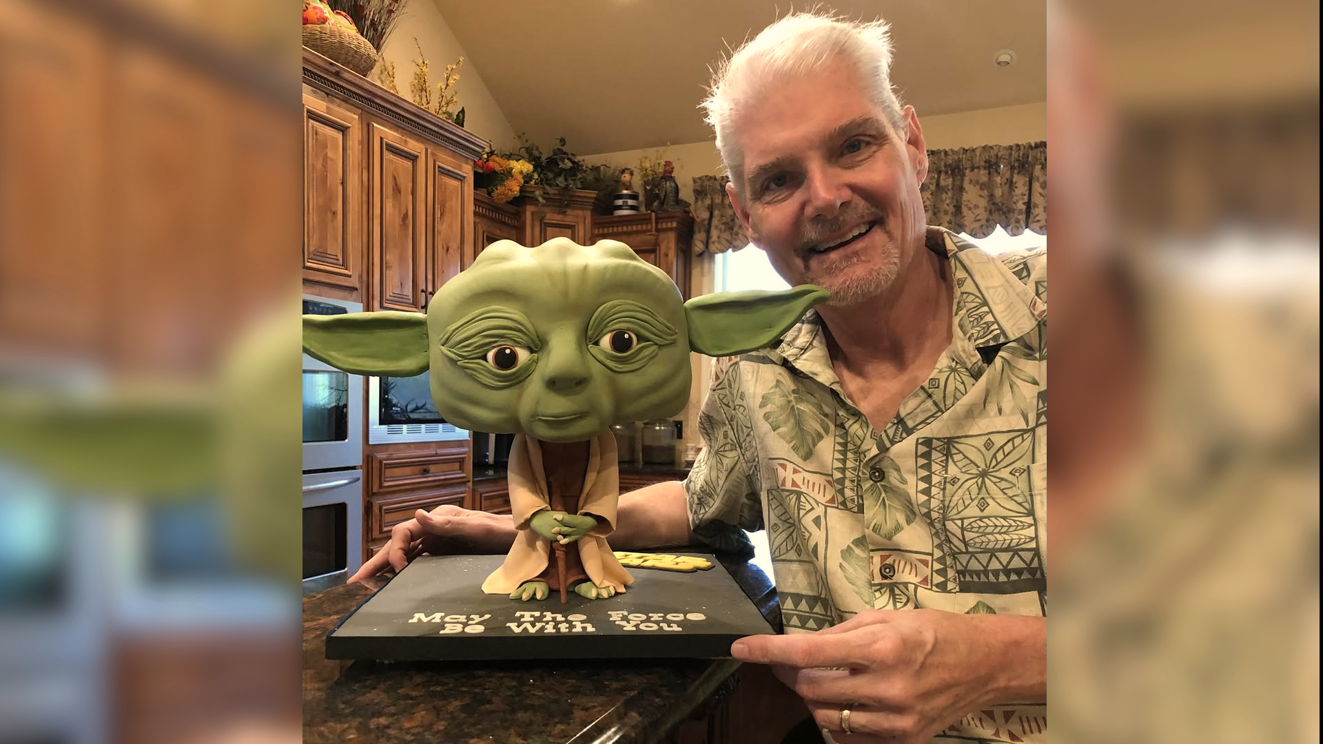 Tom Kane posing with a Yoda figurine.