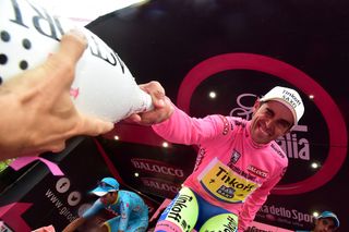 Alberto Contador winks as he grabs a bottle of champagne to celebrate on the podium after winning the 98th Giro d'Italia.