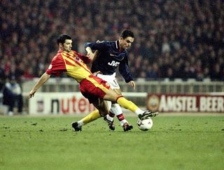 Marc Overmars of Arsenal is tackled by Yoanu Lachor of Lens during the UEFA Champions League match at Wembley in London. Arsenal lost 1-0 to crash out of the competition.