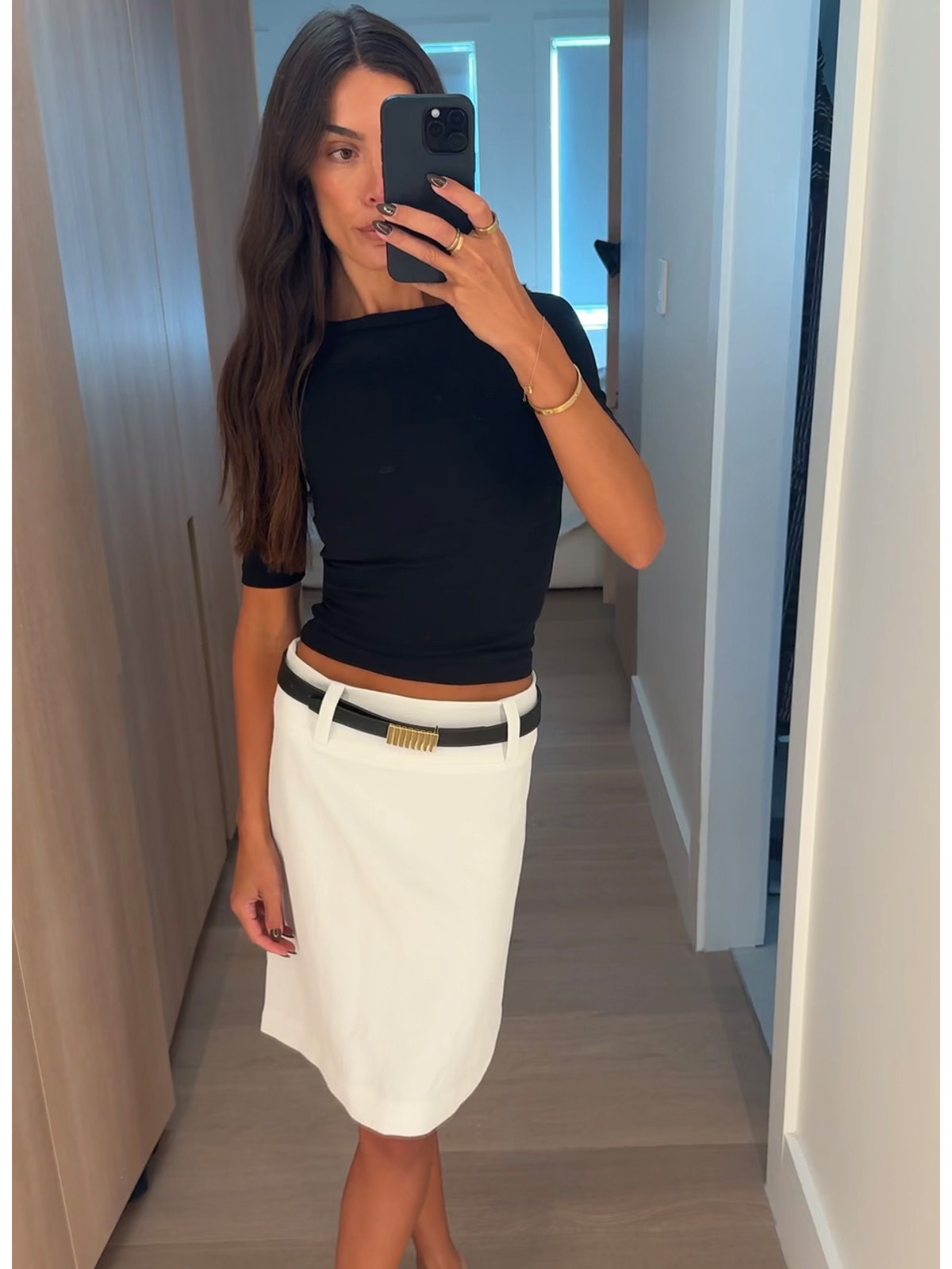 Bianca wears a white skirt and black top.