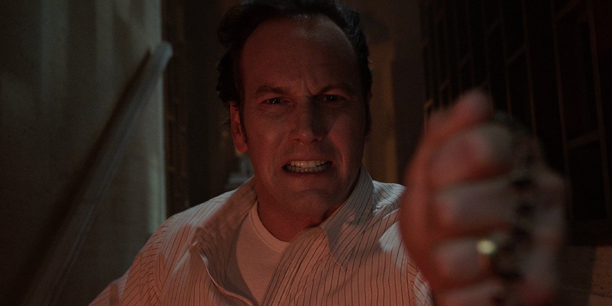 Patrick Wilson as Ed Warren holding up a cross in The Conjuring: The Devil Made Me Do It