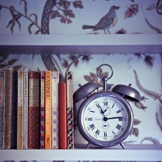 room with clock and books on table