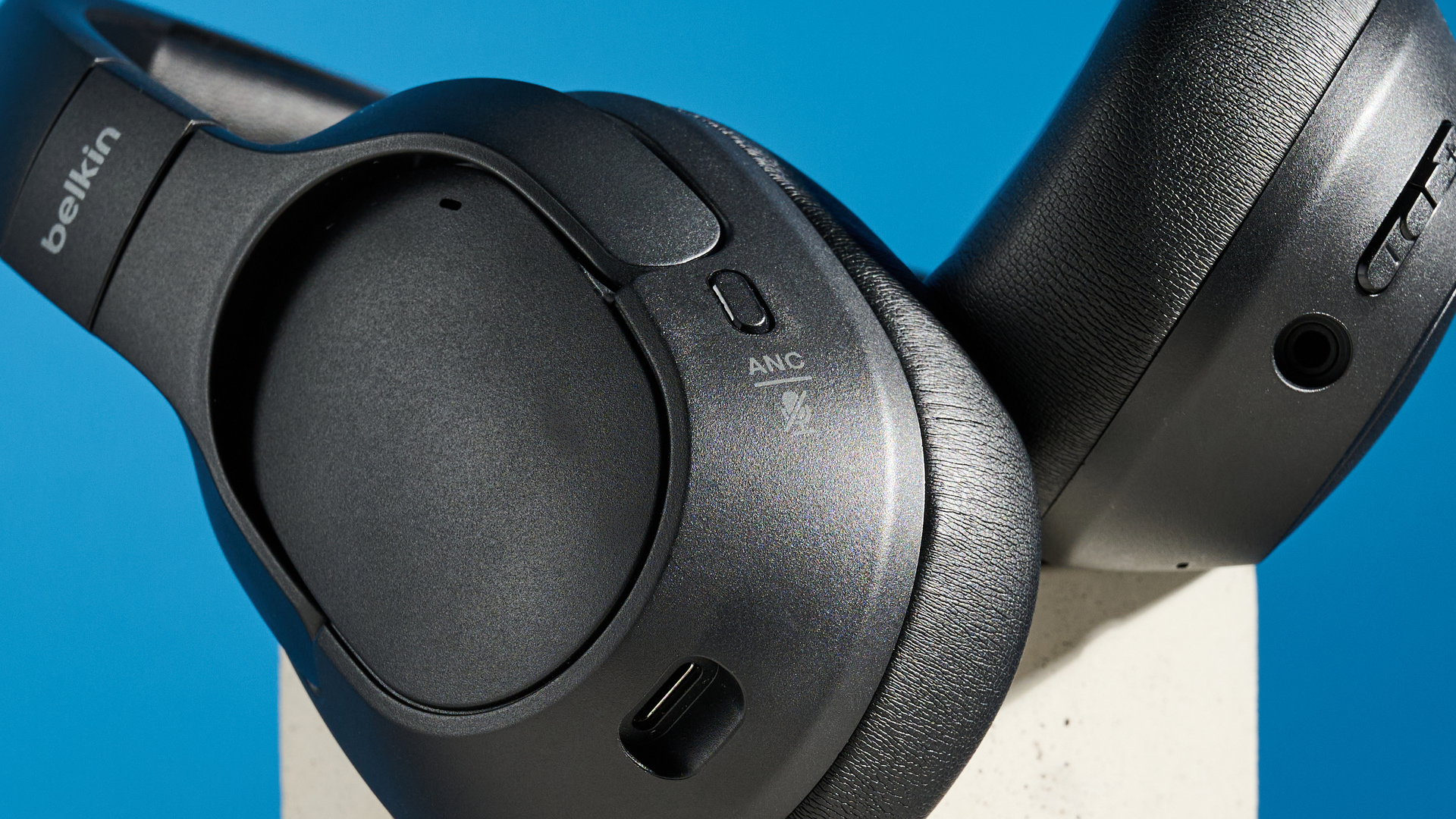 the belkin soundform isolate are a pair of budget headphones in black, with soft pillowy cups, control buttons on each cup, and ANC