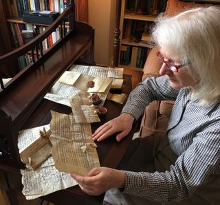 Margaret Condon, an honorary research associate at the University of Bristol, studies a 500-year-old parchment.