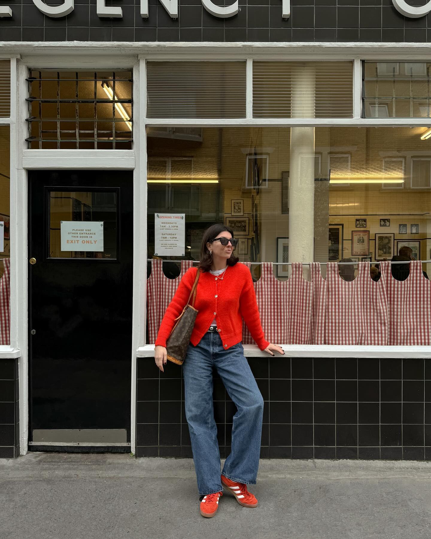 Spring trainer outfits: @francescasaffari wears a red cardigan, baggy jeans and trainers