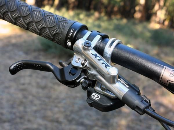 The new XTR Trail master cylinder abandons the old one's radial layout in favor of a more compact inline setup. Note the dimples at the end of the lever blade, too, which lend a noticeable boost in fingertip grip.