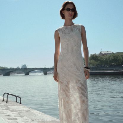 Mango model wearing Floral Crochet Dress next to a river