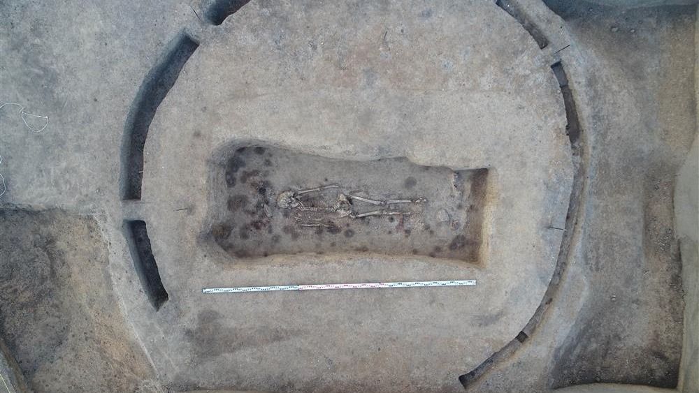 An aerial view of a burial containing a skeleton and grave goods.