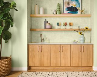 light green walls with light wood cabinets and shelves with decorative items