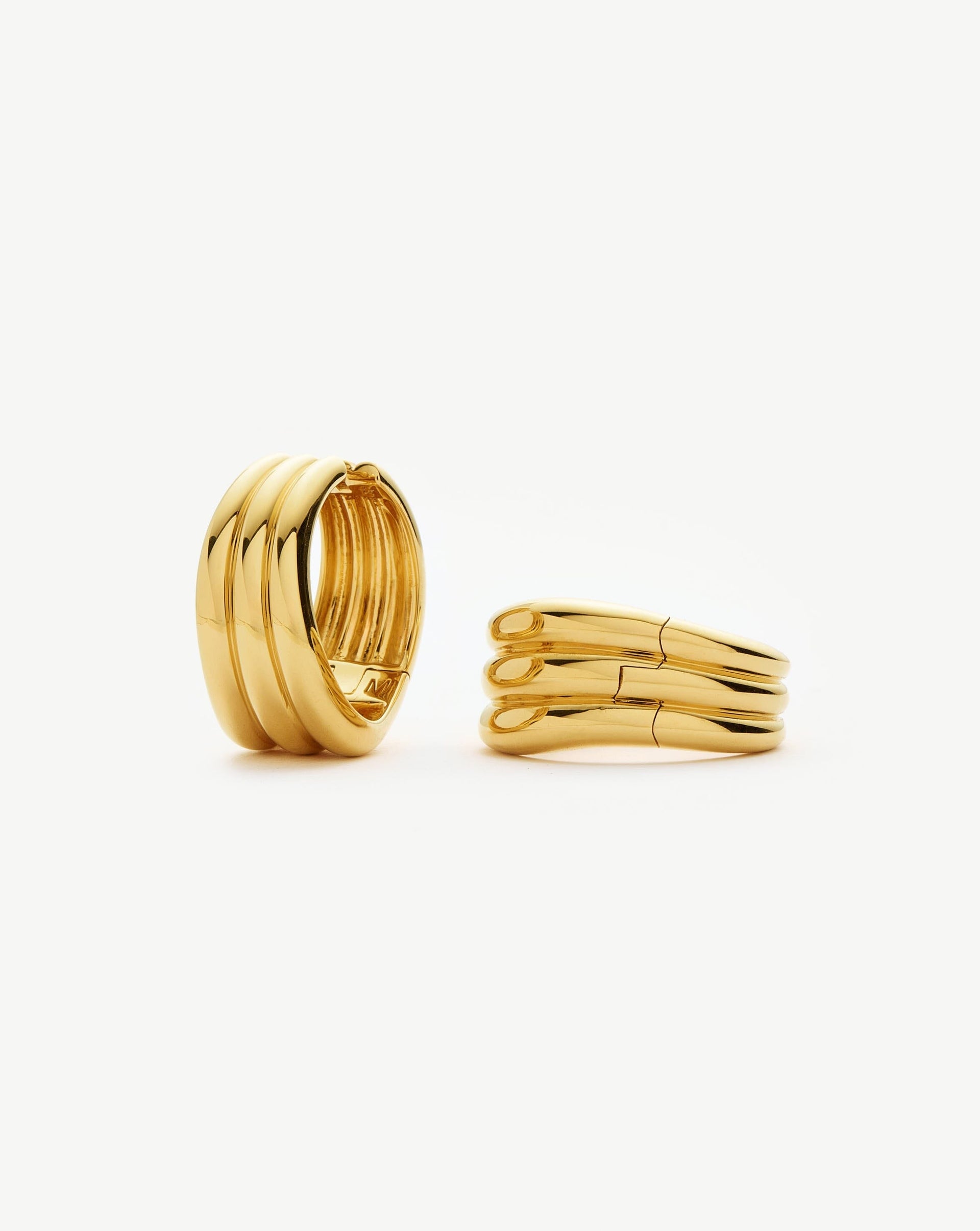 Triple ridged, medium sized gold hoop earrings.