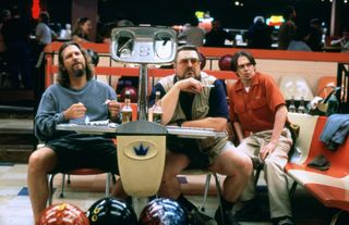 men including jeff bridges and john goodman sit around a bowling alley in the big lebowski