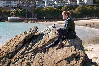Humphrey sits on a rock on the beach
