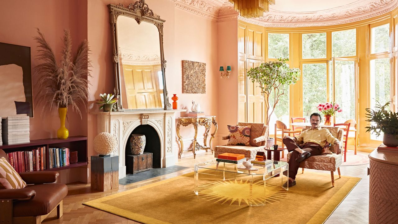 Gold rug in pink living room with large mirror