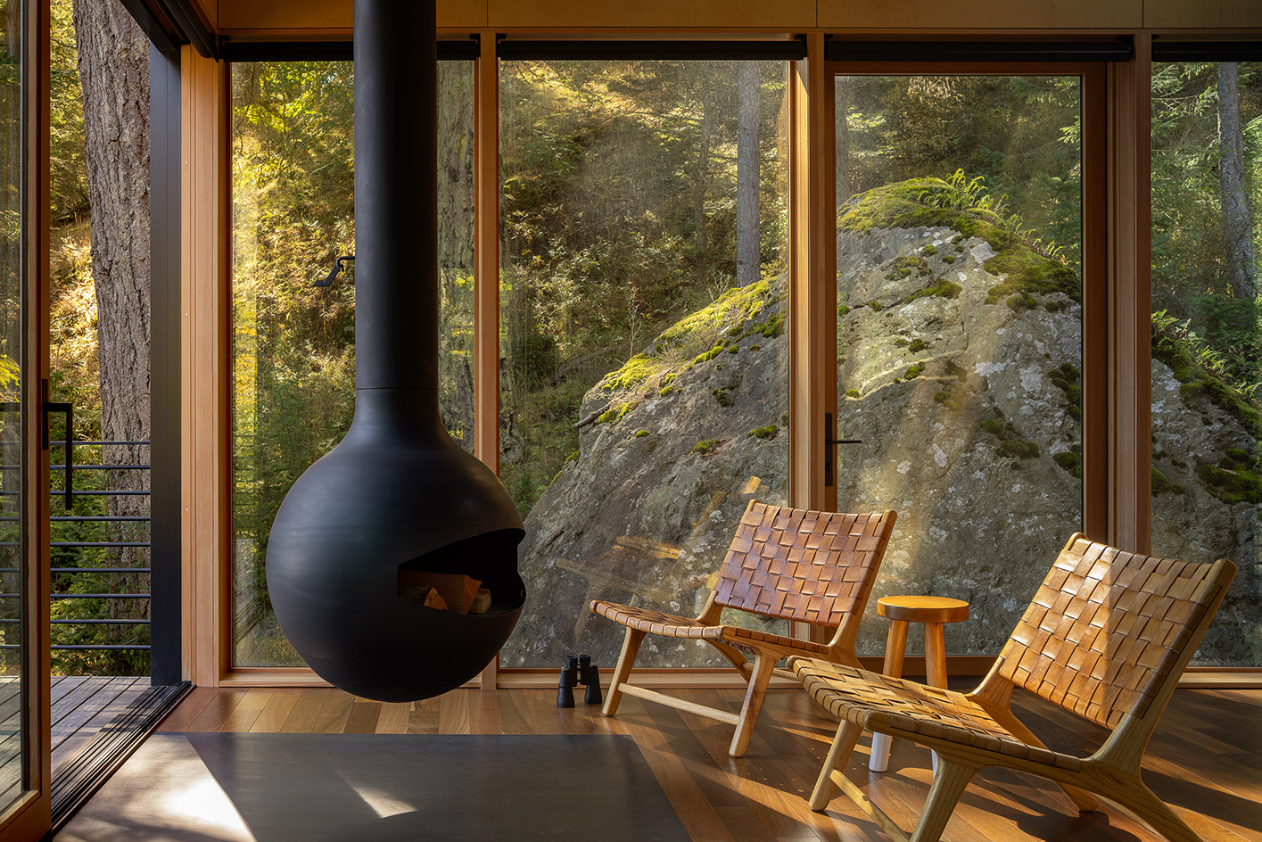 Blakely Island Cabin, a boxy structure raised on stilts above tree canopy in washington state forest