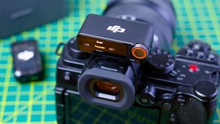 A photo of the DJI Mic 2 (RX unit) in use with a Panasonic mirrorless camera.